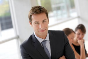 Cheerful businessman sitting in front of colleagues